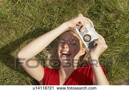 Stock Image - Young woman with fake toy camera.. Fotosearch
