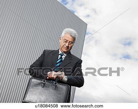 Stock Photo - Businessman by a silver wall.. Fotosearch