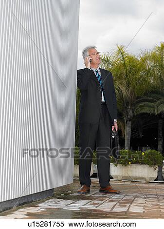 Businessman by a silver wall. View Large Photo Image Stock Photography - Businessman by a silver wall.. Fotosearch