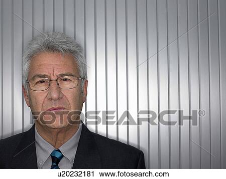 Stock Image - Businessman in front of a silver wall.. Fotosearch