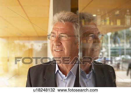 Stock Image - Man standing half in half out of doorway.. Fotosearch