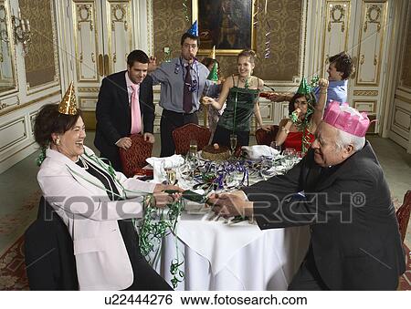 Senior couple pulling cracker at family gathering View Large Photo Image Stock Photograph - Senior couple pulling cracker at family gathering. Fotosearch