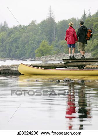 Couple holding hands on a dock near a boat. View Large Photo Image Stock Photograph - Couple holding hands on a dock near a boat.. Fotosearch