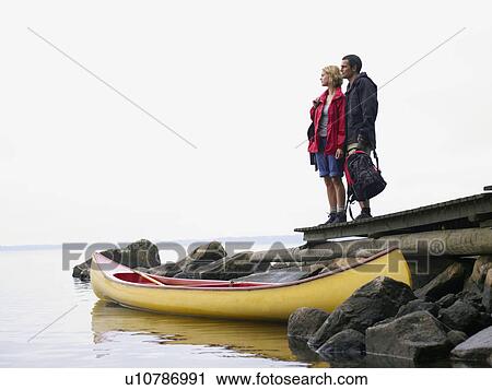 Couple standing on a dock near a boat. View Large Photo Image Stock Image - Couple standing on a dock near a boat.. Fotosearch