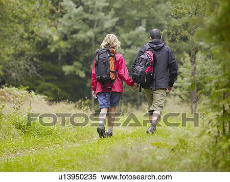 Couple walking in a park holding hands. View Large Photo Image Stock Photography - Couple walking in a park holding hands.. Fotosearch
