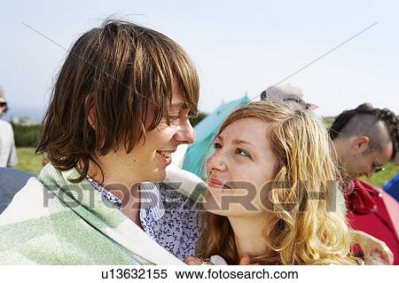 Stock Photography - Couple wrapped in blanket looking at each other. Fotosearch