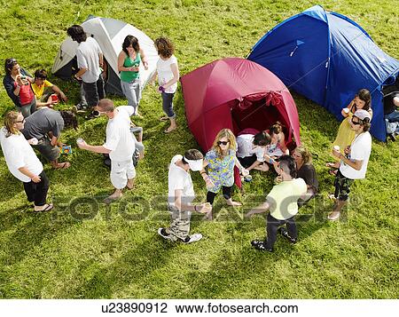 Stock Image - Group partying outside tents. Fotosearch