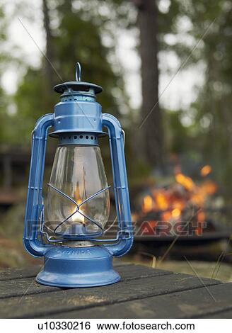 Stock Photograph - Kerosene lamp sitting on a table at campsite.. Fotosearch