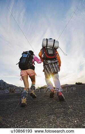 Stock Image - Man and woman hiking back view.. Fotosearch