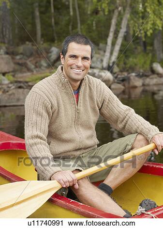 Man sitting in a boat smiling. View Large Photo Image Stock Image - Man sitting in a boat smiling.. Fotosearch