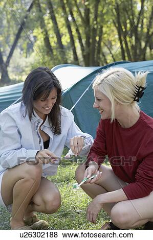 Two women at campsite putting toothpaste on toothbrushes. View Large Photo Image Stock Photo - Two women at campsite putting toothpaste on toothbrushes.. Fotosearch