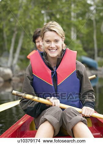 Two women in a boat smiling. View Large Photo Image Picture - Two women in a boat smiling.. Fotosearch