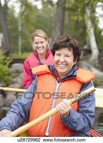 Two women in a boat smiling. View Large Photo Image Stock Image - Two women in a boat smiling.. Fotosearch
