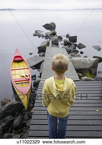 Young boy on a dock near a boat. View Large Photo Image Stock Photo - Young boy on a dock near a boat.. Fotosearch