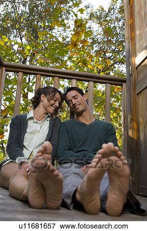 Couple sitting on deck. View Large Photo Image Stock Photo - Couple sitting on deck.. Fotosearch
