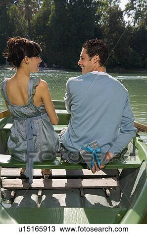 Stock Image - Man and woman in a boat with a gift. Fotosearch