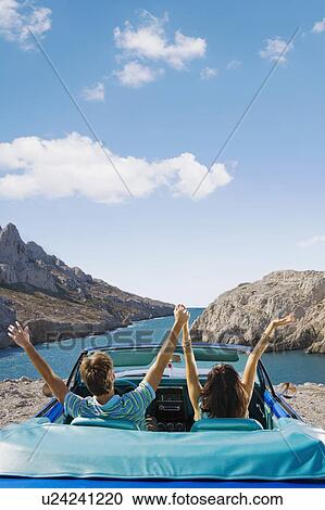 Stock Image - Man and woman in car looking out to sea.. Fotosearch