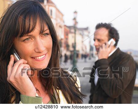 Man and woman using mobile phones. Venice, Italy. View Large Photo Image Stock Image - Man and woman using mobile phones. Venice, Italy.. Fotosearch