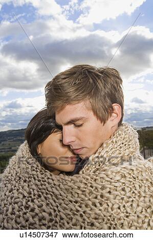 Stock Photo - Man and woman wrapped in blanket.. Fotosearch