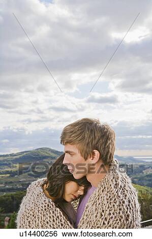 Stock Photograph - Man and woman wrapped in blanket.. Fotosearch