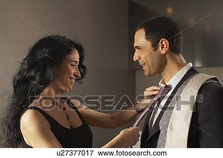 Stock Photo - Woman selecting tie for partner. Fotosearch