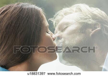 Young couple kissing through glass of window. View Large Photo Image Stock Photo - Young couple kissing through glass of window.. Fotosearch