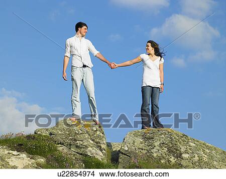 Young couple on a large rock. View Large Photo Image Picture - Young couple on a large rock.. Fotosearch
