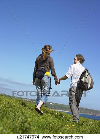 Picture - Young couple outdoors holding hands.. Fotosearch