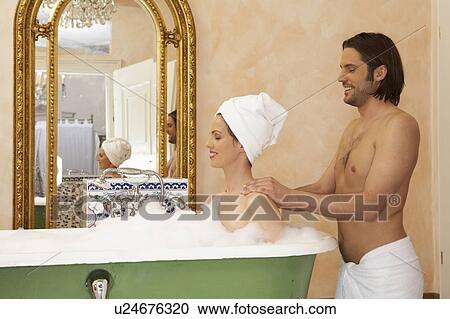 Young man smiling massaging back of woman smiling in bath, side view View Large Photo Image Stock Image - Young man smiling massaging back of woman smiling in bath, side view. Fotosearch