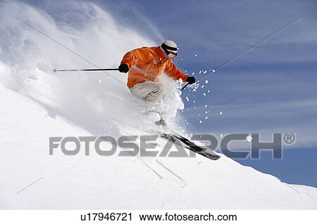 Stock Image - Austria, Saalbach, male skier jumping on slope. Fotosearch