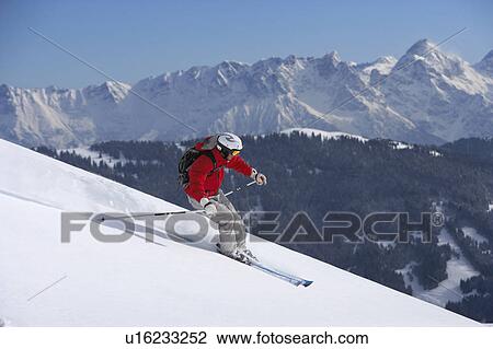 Stock Image - Austria, Saalbach, man skiing down mountain slope. Fotosearch