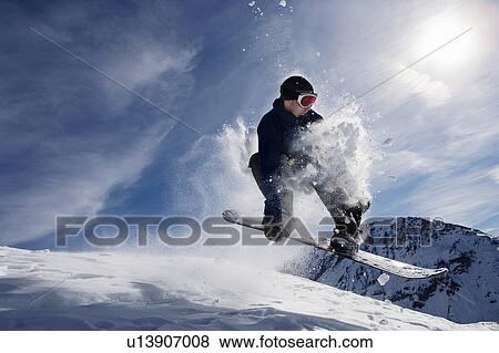 Stock Photo - Male snowboarding on mountain, action shot. Fotosearch