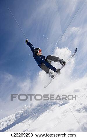 Stock Image - Male snowboarding on mountain. Fotosearch