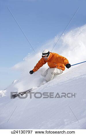 Man skiing down snow mountain slope sending up spray View Large Photo Image Stock Photo - Man skiing down snow mountain slope sending up spray. Fotosearch