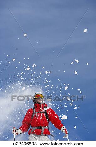 Snow spraying over male skier, low angle view View Large Photo Image Stock Photo - Snow spraying over male skier, low angle view. Fotosearch