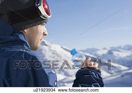 Picture - Snowboarder with water bottle, side view. Fotosearch