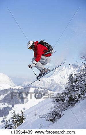 Austria, Saalbach, male skier jumping past trees on slope View Large Photo Image Stock Photo - Austria, Saalbach, male skier jumping past trees on slope. Fotosearch