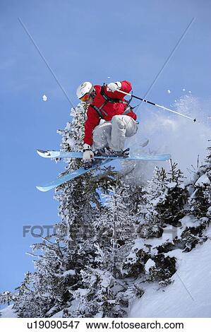 Austria, Saalbach, male skier jumping through trees with skis crossed View Large Photo Image Stock Photo - Austria, Saalbach, male skier jumping through trees with skis crossed. Fotosearch