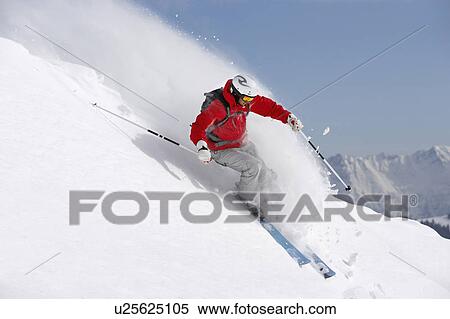 Stock Photography - Austria, Saalbach, male skier turning in snow on slope. Fotosearch