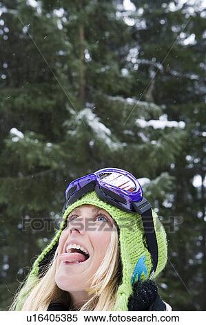 Close-up of young blonde woman wearing ski-wear sticking tongue out to catch snow View Large Photo Image Stock Photography - Close-up of young blonde woman wearing ski-wear sticking tongue out to catch snow. Fotosearch