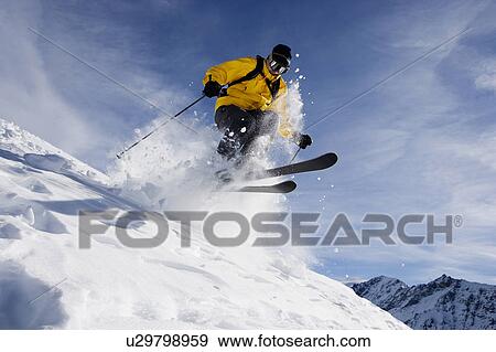 Male skiing over mountain ridge View Large Photo Image Stock Photo - Male skiing over mountain ridge. Fotosearch