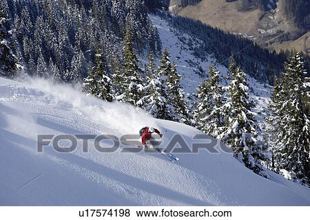 Stock Photo - Man skiing down snow mountain slope, overhead view. Fotosearch