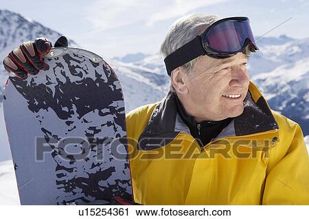 Stock Image - Mature male snowboarder on mountain, close-up, portrait. Fotosearch