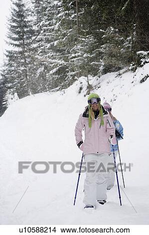 Two young blonde women walking in forest using snow-shoes View Large Photo Image Picture - Two young blonde women walking in forest using snow-shoes. Fotosearch