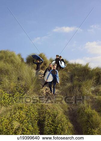 Stock Image - Five teenagers walking down a grass bank.. Fotosearch