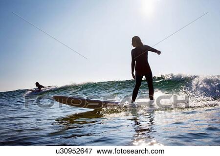 Stock Photo - Man and woman surfing.. Fotosearch