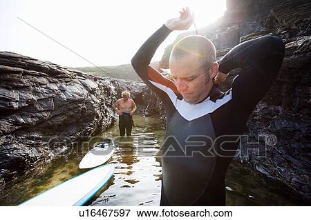 Two men in the water getting ready to surf. View Large Photo Image Stock Photo - Two men in the water getting ready to surf.. Fotosearch