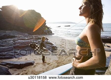 Couple standing on beach with surfboards. View Large Photo Image Stock Photo - Couple standing on beach with surfboards.. Fotosearch