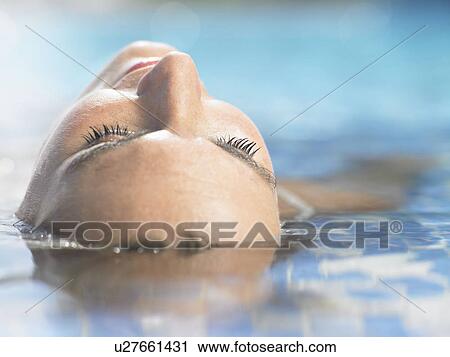 A woman floating in hotel pool View Large Photo Image Stock Image - A woman floating in hotel pool. Fotosearch