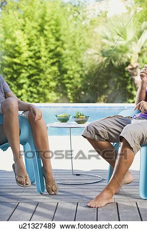 Couple on a wooden terrace by a pool View Large Photo Image Stock Photo - Couple on a wooden terrace by a pool. Fotosearch